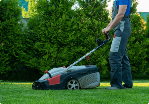 young-gardener-overalls-uses-lawn-mower-plot